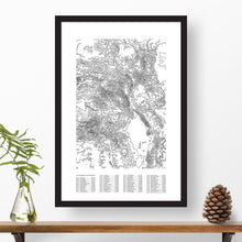 Load image into Gallery viewer, Colorado 14ers topographic map poster, 24"x36", in a vertical orientation, with a black solid wood ready-to-hang frame. The legend lists all 58 of Colorado's tallest mountains with elevations and a checklist to mark progress on summiting.