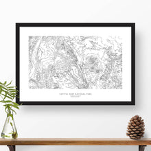 Load image into Gallery viewer, Map wall decor in a black frame. Contour lines of Capitol Reef National Park are drawn on a white background. Text  below the map can be customized to create custom adventure art.
