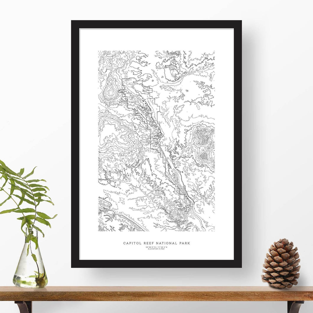 National park print of Capitol Reef with black and white topography in a black 24x36 vertical frame.